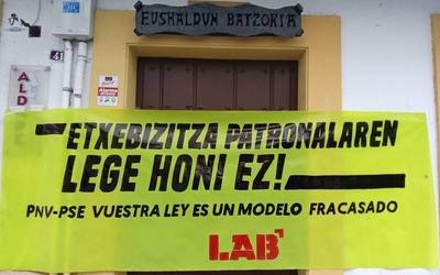 LABek Premiazko Neurrien legea salatzeko pankartak jarri ditu Arrasateko EAJ eta PSEren egoitzetan